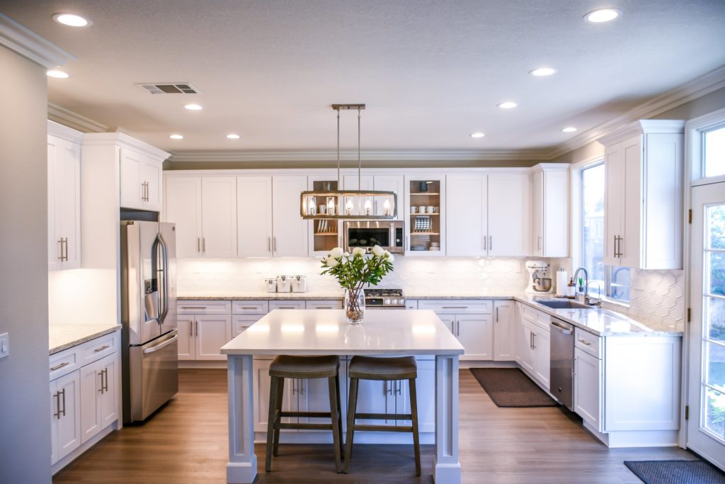 See how this hardwood floor adds value to an already beautiful kitchen space with white cabinets.